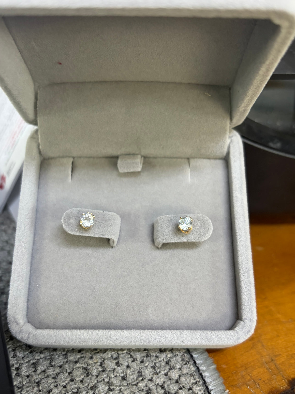 Pair of 14K yellow gold natural aquamarine and diamond earrings displayed in a jewelry box