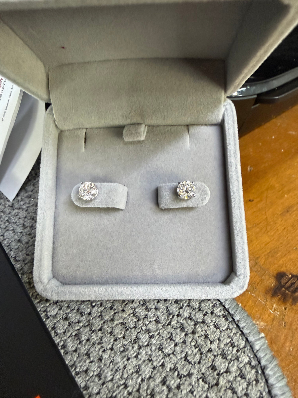 Pair of 14K white gold 1.50ctw lab diamond earrings displayed in a jewelry box