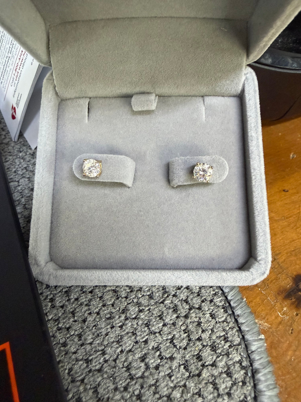 Pair of 14K yellow gold 1ct lab diamond earrings displayed in a jewelry box