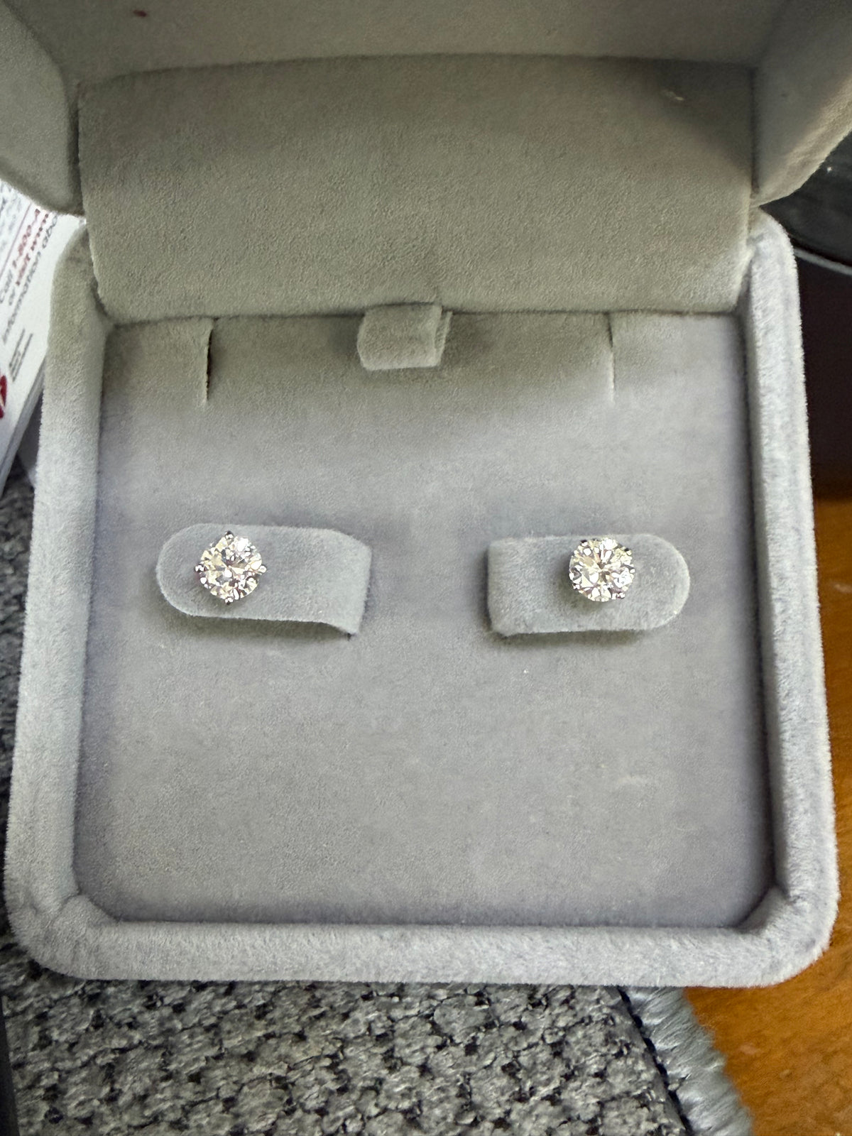Pair of 14K white gold 1.20ctw lab diamond earrings displayed in a jewelry box