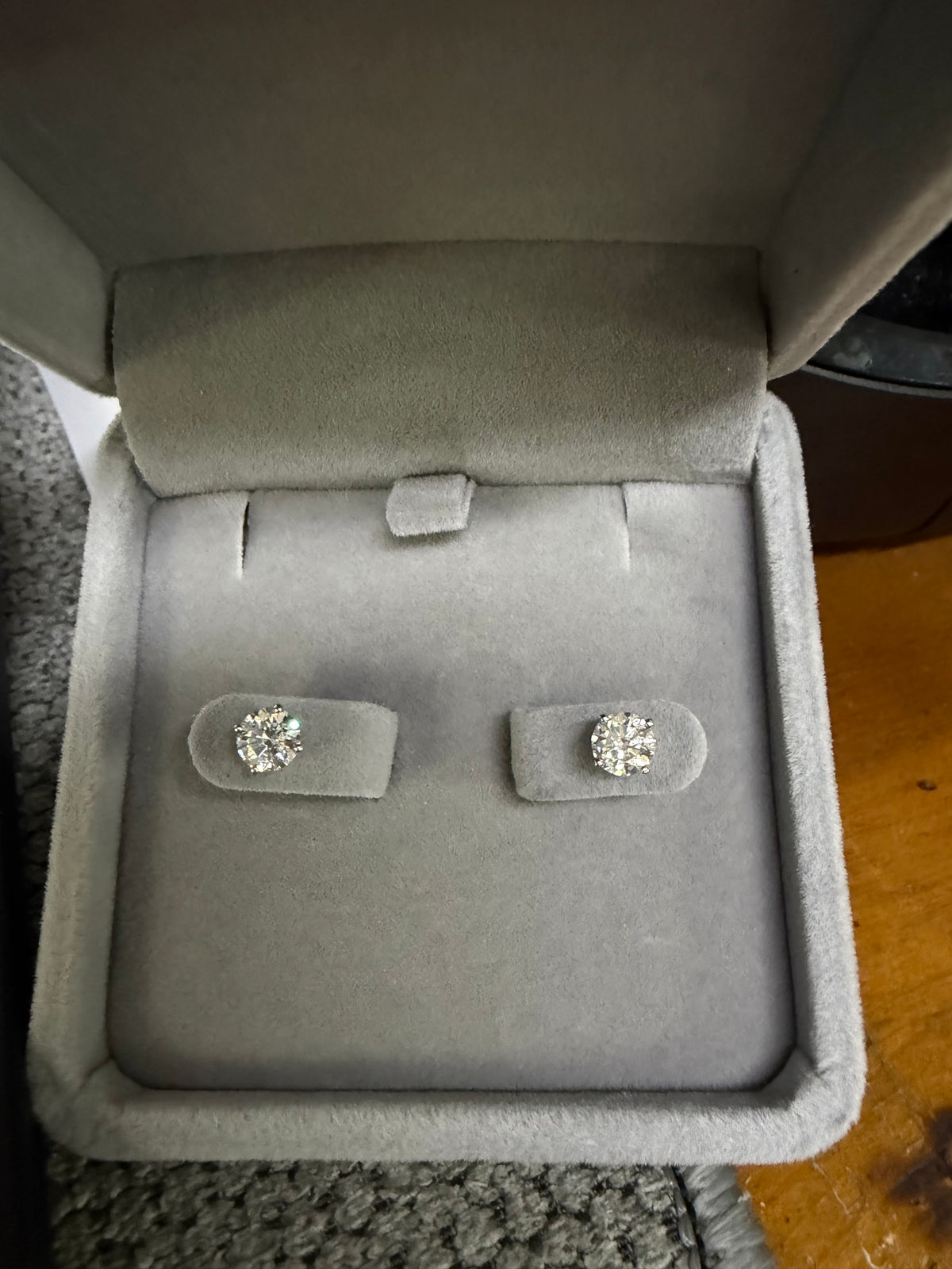 Pair of 14K white gold 1.20ctw lab diamond earrings displayed in a jewelry box