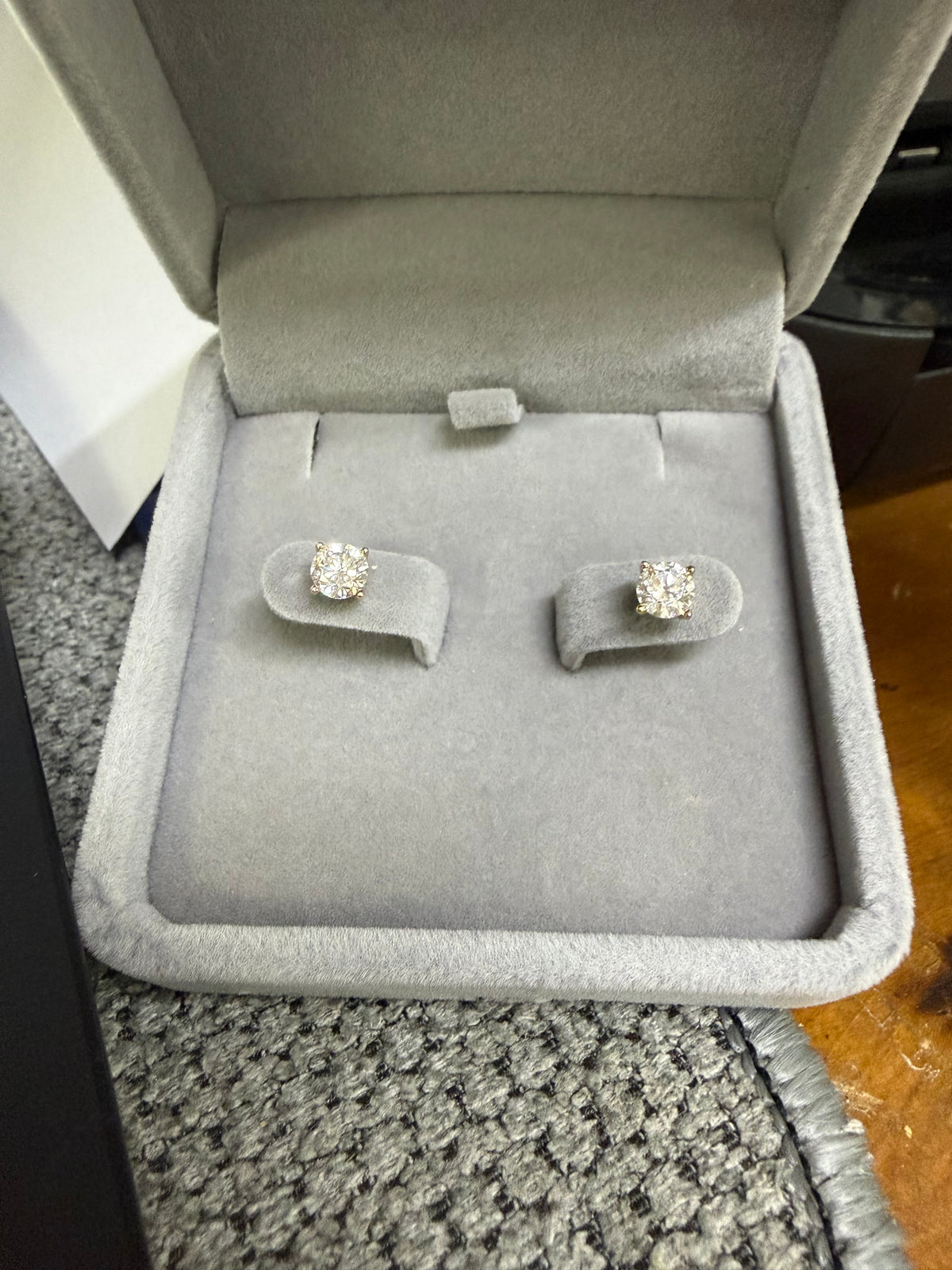 Pair of 14K yellow gold 1ct lab diamond earrings displayed in a jewelry box