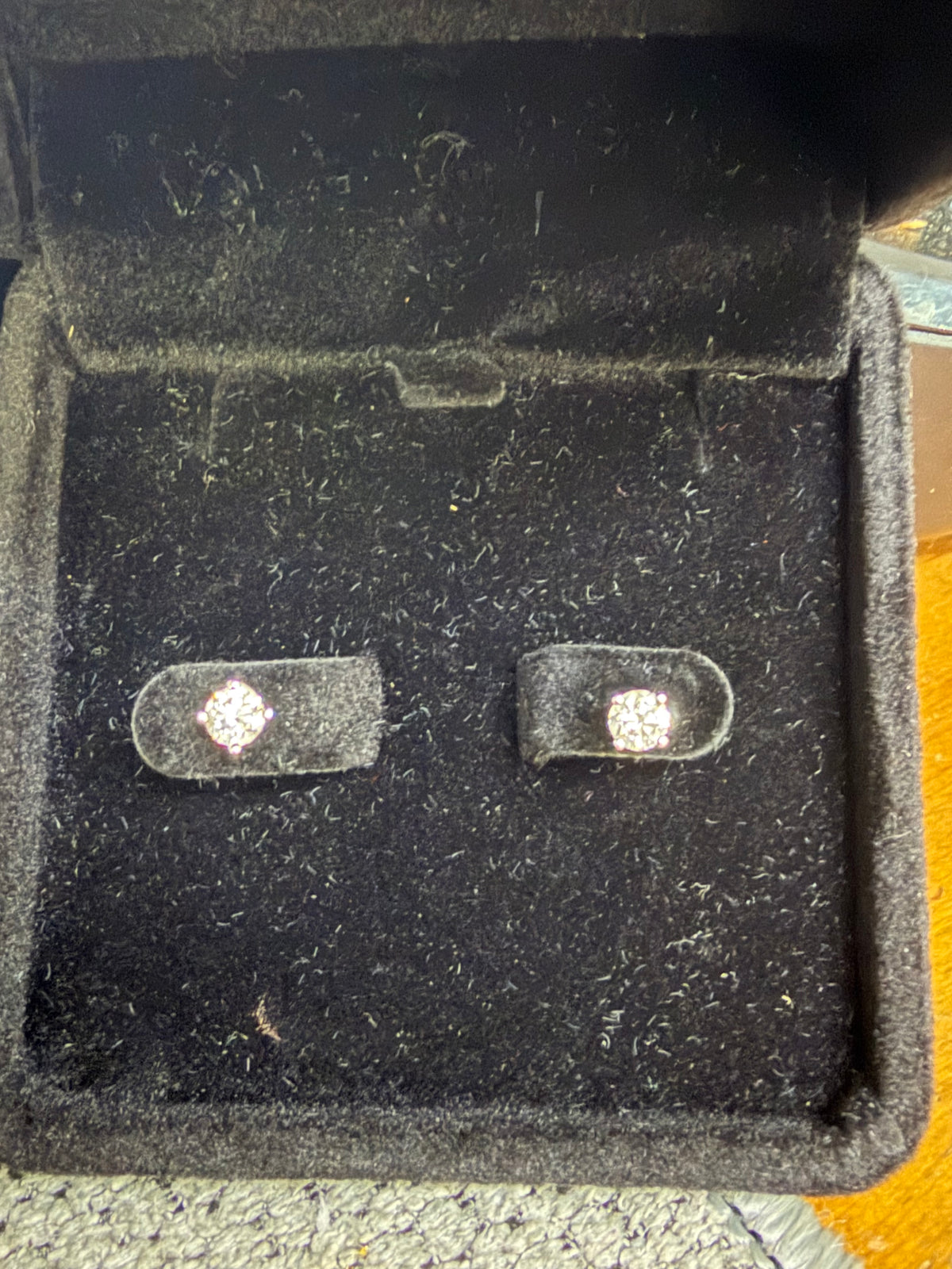 Pair of 14K white gold 0.50ctw natural diamond earrings displayed in a jewelry box