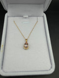 Pear-shaped blush morganite pendant with diamond accents in yellow gold, shown with a chain in a jewelry box