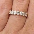 14K yellow gold band with a row of oval lab-grown diamonds, shown on a finger